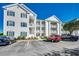 Three-story condo building featuring white siding, blue shutters, and private balconies with parking at 901 West Port Dr. # 2101, North Myrtle Beach, SC 29582