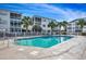 Inviting swimming pool surrounded by white lounge chairs and tropical palm trees at 901 West Port Dr. # 2101, North Myrtle Beach, SC 29582