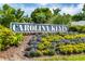 Community signage for Carolina Keyes surrounded by colorful flowerbeds and lush greenery at 901 West Port Dr. # 2101, North Myrtle Beach, SC 29582
