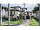 A stunning multi-story white home featuring a driveway, lush landscaping, and dark trim accents at 918 Strand Ave., North Myrtle Beach, SC 29582
