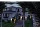 A night view of the home featuring sconce lights, mature landscaping, and a paver driveway at 918 Strand Ave., North Myrtle Beach, SC 29582