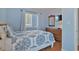 Bright bedroom with a floral patterned bedspread, wood-look floors, and a dresser with a mirror at 9580 Shore Dr. # 311, Myrtle Beach, SC 29572