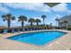Inviting outdoor pool area with lounge chairs, palm trees, and a clear blue sky at 9580 Shore Dr. # 311, Myrtle Beach, SC 29572