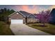 Beautiful brick home with a two car garage, manicured lawn, and lovely landscaping under a colorful sunset sky at 1112 Raven Cliff Ct., Conway, SC 29526