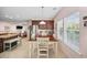 Eat-in kitchen boasts natural light, stainless steel appliances, a wooden dining table, and pink walls at 1112 Raven Cliff Ct., Conway, SC 29526