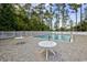 Community pool with tables, a brick paver surround, fenced area and surrounded by trees at 329 Lake Mist Ct., Longs, SC 29568