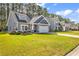 Charming home with manicured lawn, colorful flower beds, and attached two-car garage at 329 Lake Mist Ct., Longs, SC 29568