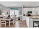 Open concept dining and kitchen area with white cabinetry, wood flooring, and stainless steel appliances at 329 Lake Mist Ct., Longs, SC 29568