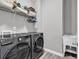 Functional laundry room with modern washer/dryer units, storage shelf, and convenient utility sink at 329 Lake Mist Ct., Longs, SC 29568