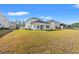 Spacious backyard featuring a well-maintained lawn and the rear of a bright, modern home with a sunroom at 4032 Bayhill St., Myrtle Beach, SC 29579