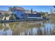 Charming blue home with mature landscaping and serene waterfront views from the rear at 613 23Rd Ave. N, North Myrtle Beach, SC 29582