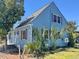 Exterior view of a charming blue two-story home featuring wood shutters and a well manicured yard at 613 23Rd Ave. N, North Myrtle Beach, SC 29582