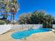 Inviting kidney-shaped pool surrounded by a white fence and lush landscaping offering a private outdoor oasis at 613 23Rd Ave. N, North Myrtle Beach, SC 29582