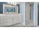 Well-lit bathroom with a double vanity, white cabinets, and a walk-in shower at 707 S Ocean Blvd. # 602, North Myrtle Beach, SC 29582