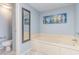 Relaxing bathroom with a soaking tub, serene blue walls, and nautical-themed artwork at 707 S Ocean Blvd. # 602, North Myrtle Beach, SC 29582