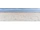 Sandy beach with gentle waves washing ashore, scattered with seaweed and footprints at 707 S Ocean Blvd. # 602, North Myrtle Beach, SC 29582