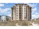 Exterior view of a beachfront condominium building featuring multiple balconies and a landscaped yard at 707 S Ocean Blvd. # 602, North Myrtle Beach, SC 29582