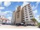 Multi-story condo building with parking and landscaping set against a bright blue, cloudy sky at 707 S Ocean Blvd. # 602, North Myrtle Beach, SC 29582