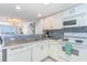 Galley kitchen featuring white cabinets, breakfast bar and mosaic tile backsplash at 707 S Ocean Blvd. # 602, North Myrtle Beach, SC 29582