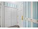 Bright entryway with blue striped wallpaper, a coat rack, and closet for storage at 95 Weehawka Way # 2, Pawleys Island, SC 29585