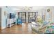 Bright living room with wood floors, ceiling fan, blue accent wall, and sliding glass doors at 95 Weehawka Way # 2, Pawleys Island, SC 29585