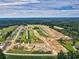 Expansive aerial view of new construction homes and development of lots with lush green space and wooded backdrop at 997 Oak Hollow St., Longs, SC 29568