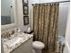 Well-maintained bathroom features a granite countertop, decorative mirror, and coordinated shower curtain at 1025 Ray Costin Way # 1008, Murrells Inlet, SC 29576