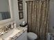 Well-maintained bathroom features a granite countertop, decorative mirror, and coordinated shower curtain at 1025 Ray Costin Way # 1008, Murrells Inlet, SC 29576