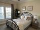 Cozy bedroom featuring a wrought iron bed frame, ceiling fan, and serene decor with bright natural light at 1025 Ray Costin Way # 1008, Murrells Inlet, SC 29576