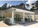 Community clubhouse featuring a covered porch with pastel chairs, great for relaxing and socializing at 1025 Ray Costin Way # 1008, Murrells Inlet, SC 29576