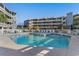 Exterior view of a sparkling in-ground pool with lounge chairs on the sundeck at 1101 Possum Trot Rd. # C-303, North Myrtle Beach, SC 29582