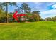 The backyard of the house on the golf course has beautiful green grass and various trees at 110-4 White Tail Way # 4, Pawleys Island, SC 29585