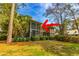 A view of the backyard and screened-in porch, surrounded by mature landscaping and lawn at 110-4 White Tail Way # 4, Pawleys Island, SC 29585