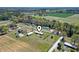 A high aerial shot showing a house with a map marker and the surrounding grassy fields and wooded areas at 1136 Knotty Branch Rd., Conway, SC 29527