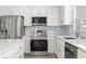 Bright kitchen with stainless steel appliances, gray backsplash, white cabinetry, and a sink looking out a window at 1136 Knotty Branch Rd., Conway, SC 29527