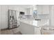 Bright kitchen with stainless steel appliances, gray backsplash, white cabinetry, and an island with quartz countertop at 1136 Knotty Branch Rd., Conway, SC 29527