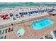 Aerial view showing a beachside pool, ocean, and beachgoers, offering a vibrant vacation atmosphere at 1210 N Waccamaw Dr. # 408, Garden City Beach, SC 29576