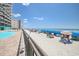 Picturesque beach view featuring blue umbrellas near a condo building and pool on a sunny day at 1210 N Waccamaw Dr. # 408, Garden City Beach, SC 29576
