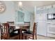 This dining area features a round wooden table with 4 chairs and is located adjacent to the kitchen at 1210 N Waccamaw Dr. # 408, Garden City Beach, SC 29576