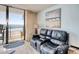 This living room features a reclining sofa with an ocean view from the sliding glass door and balcony at 1210 N Waccamaw Dr. # 408, Garden City Beach, SC 29576