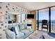 Bright living room with balcony access offering stunning ocean views from the sliding glass doors at 1210 N Waccamaw Dr. # 408, Garden City Beach, SC 29576