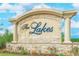 Stone entrance sign reading 'The Lakes', enhanced by lush landscaping and bright skies at 138 Cooper River Rd., Myrtle Beach, SC 29588