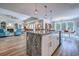 Open-concept kitchen with a large granite island, modern lighting, and views into the connected living and dining areas at 138 Cooper River Rd., Myrtle Beach, SC 29588