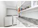 Bright laundry room with granite countertops, white cabinetry and modern washer and dryer at 138 Cooper River Rd., Myrtle Beach, SC 29588