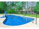 Inviting backyard pool with a basketball hoop, surrounded by lush greenery and a fence at 138 Cooper River Rd., Myrtle Beach, SC 29588