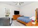 Bright bedroom with a ceiling fan, large window, wood dresser, and a comfortable wooden bed frame at 1470 Burriss Rd., Conway, SC 29526
