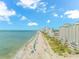 Expansive beach view with the ocean, beach, and resorts under a blue sky and fluffy white clouds at 1501 S Ocean Blvd. # 1042, Myrtle Beach, SC 29577