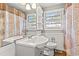 Bright bathroom features white vanity, toilet, window, and patterned shower curtain at 1502 Mckeithan St., Conway, SC 29526