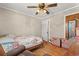 Bedroom with hardwood floors, ceiling fan, boxes, and floral bedding at 1502 Mckeithan St., Conway, SC 29526
