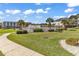 Community pool with palm trees, lush landscaping and several condos in the background on a sunny day at 1505 Lanterns Rest Rd. # 101, Myrtle Beach, SC 29579
